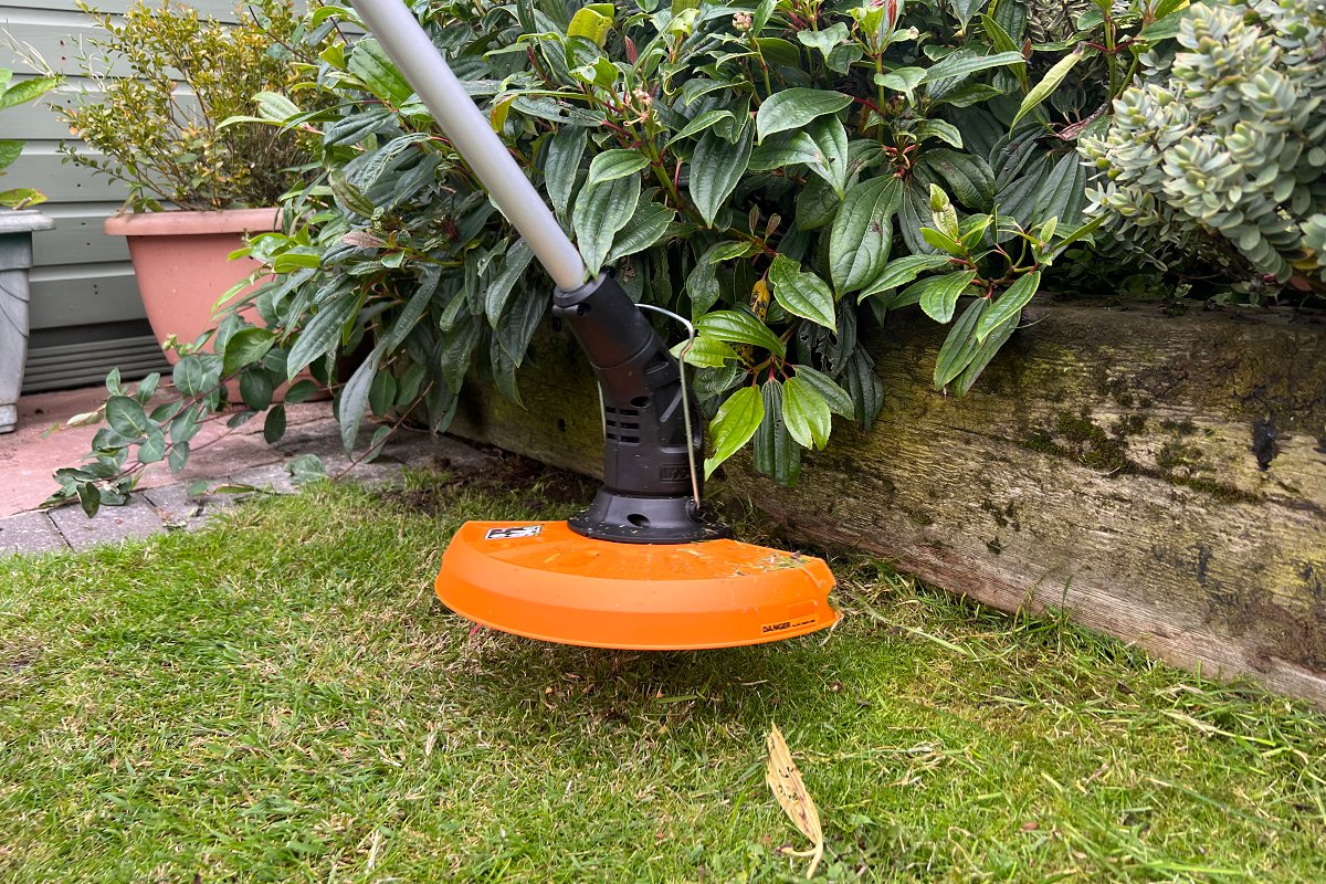 stringer trimmer cutting in tight space around the edge of the lawn