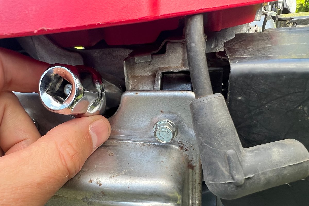 Putting socket on lawn mower spark plug to remove it